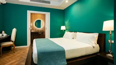 a bedroom with a green wall with a bed and a desk at Hotel Ramblas Internacional in Barcelona