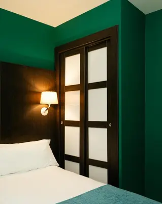 a bedroom with a bed and a green wall at Hotel Ramblas Internacional in Barcelona