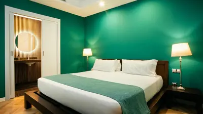 a bedroom with a large bed with a green wall at Hotel Ramblas Internacional in Barcelona