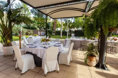 a table set up for a wedding reception under a pergola at Abba Garden in Barcelona