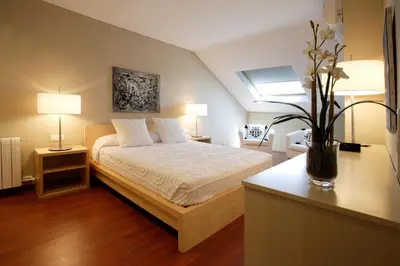 a bedroom with a bed and two tables and two lamps at Habitat Apartments Tessa in Barcelona