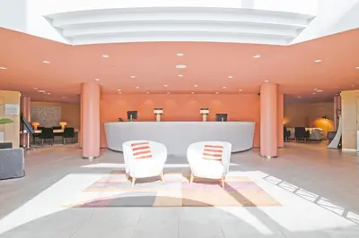 a lobby with two white chairs and a table at Acta Sant Just in Sant Just Desvern