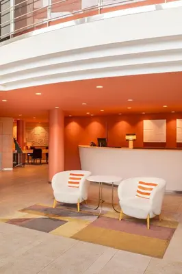 a lobby with two white chairs and a table at Acta Sant Just in Sant Just Desvern