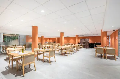 a dining room with wooden tables and chairs at Acta Sant Just in Sant Just Desvern