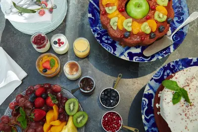 a table topped with plates of fruit and desserts at Acta Splendid in Barcelona