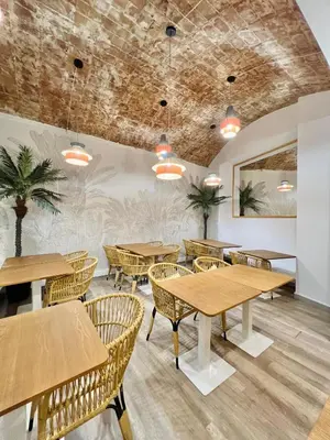 a restaurant with wooden tables and rattan chairs at ITC Barcelona By Soho Boutique in Barcelona