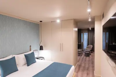 a hotel room with a bed and a living room at Atenea Rekord Suites Barcelona in Barcelona