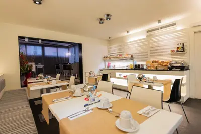 a restaurant with tables and chairs and a kitchen at Atenea Rekord Suites Barcelona in Barcelona