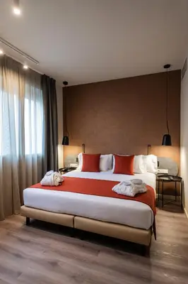 a bedroom with a large bed with red and white pillows at Atenea Rekord Suites Barcelona in Barcelona