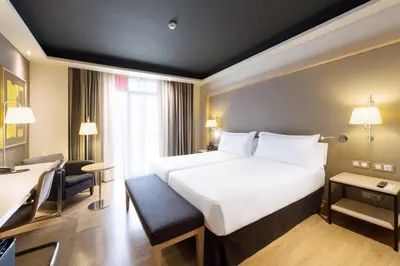 a hotel room with a large white bed and a desk at Hotel Jazz in Barcelona