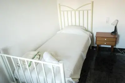 a bedroom with a white bed and a night stand at Habitación doble con Balcón - Casa rural compartida - Coliving in Torrellas de Foix