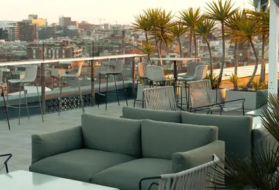 a patio with chairs and a couch on a balcony at Catalonia Barcelona Plaza in Barcelona