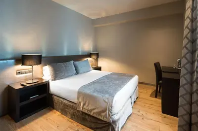 a hotel room with a bed and a desk at Catalonia Portal de l'Angel in Barcelona