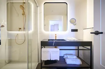 a bathroom with a sink and a shower with a mirror at Catalonia Portal de l'Angel in Barcelona