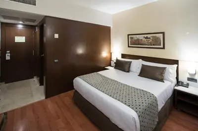a hotel room with a large bed and a bathroom at Catalonia Born in Barcelona