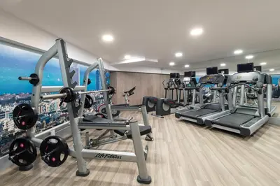a gym with several tread machines in a room at Catalonia Sagrada Familia in Barcelona