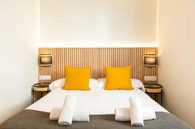 a bedroom with a bed with two yellow pillows at Sitges Group Ocean in Sitges