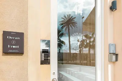 a door with a window with a palm tree on it at Sitges Group Ocean in Sitges