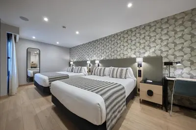 a hotel room with two beds and a television at Catalonia Park Güell in Barcelona