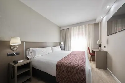 a hotel room with a bed and a window at Catalonia Park Güell in Barcelona