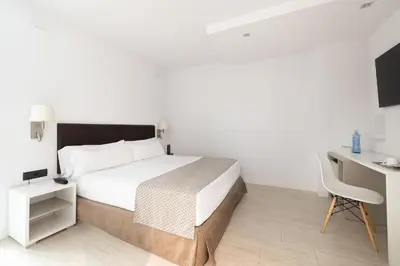 a bedroom with a bed and a desk and a television at Catalonia Albeniz in Barcelona
