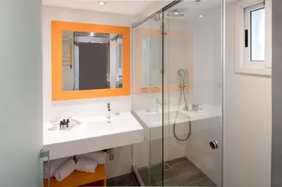 a bathroom with a sink and a glass shower at Catalonia Mikado in Barcelona