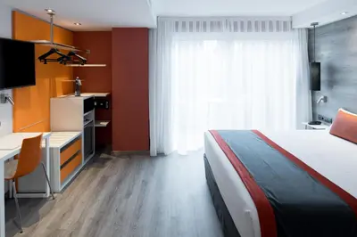 a hotel room with a bed and a desk and a television at Catalonia Mikado in Barcelona
