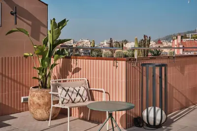 a chair and a table on a balcony with a plant at Catalonia Park Putxet in Barcelona