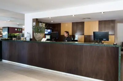 a woman sitting at a counter in a hotel lobby at Catalonia Atenas in Barcelona