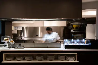 a chef standing in a kitchen preparing food at Catalonia Atenas in Barcelona