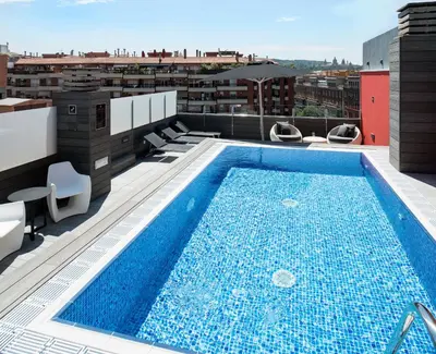 a swimming pool on the roof of a building at Catalonia Roma in Barcelona