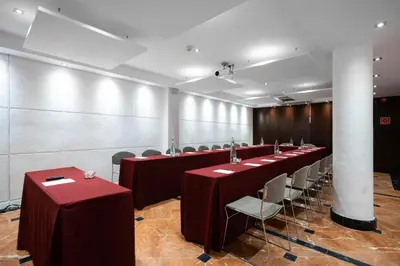 a row of tables and chairs in a room at Catalonia Roma in Barcelona