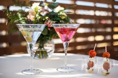 a table with two martini glasses and a vase of flowers at Hotel Balmoral in Barcelona