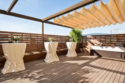 a patio with two white vases on a wooden deck at Hotel Balmoral in Barcelona
