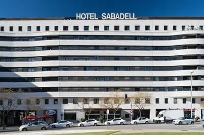 a hotel saada building with cars parked in front of it at Catalonia Sabadell in Sabadell