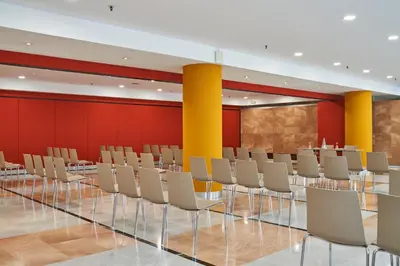 a conference room with white chairs and red walls at Catalonia Sabadell in Sabadell