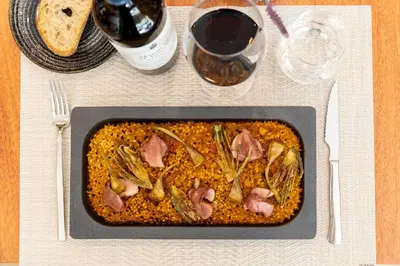 a dish of food on a table with a glass of wine at Catalonia Gran Hotel Verdi in Sabadell
