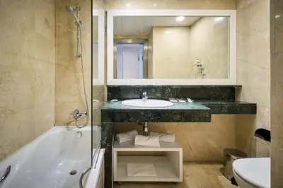 a bathroom with a sink and a tub and a mirror at Catalonia Bristol in Sant Andreu de la Barca