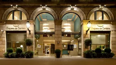 a large building with lights on the front of it at Duquesa de Cardona Hotel 4 Sup by Grup Duquessa in Barcelona