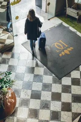 a woman walking down a sidewalk with a suitcase at Duquesa de Cardona Hotel 4 Sup by Grup Duquessa in Barcelona