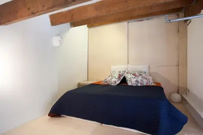 a bedroom with a bed with a blue comforter and pillows at Beach Loft Duplex in Barcelona