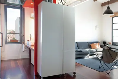 a large white cabinet in a living room with a couch at Beach Loft Duplex in Barcelona