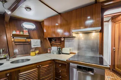 a kitchen with wooden cabinets and a sink and a stove at SPACIOUS YACHT HOTEL BARCELONA CITY CENTER 5 CABINs in Barcelona