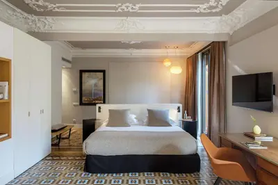 a hotel room with a bed and a desk at Alexandra Barcelona Hotel, Curio Collection by Hilton in Barcelona