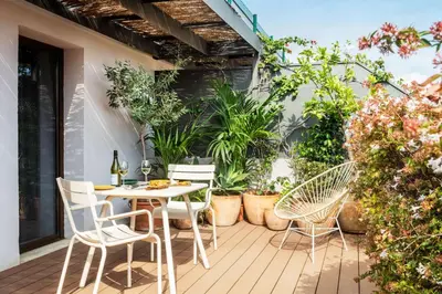a patio with a table and chairs and plants at Alexandra Barcelona Hotel, Curio Collection by Hilton in Barcelona