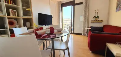 a living room with a table with chairs and a television at Lovely Appart & Sky View SAGRADA FAMILIA in Barcelona