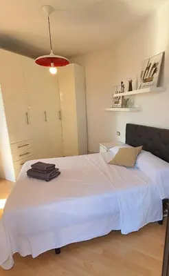 a bedroom with a large white bed with a red light at Lovely Appart & Sky View SAGRADA FAMILIA in Barcelona