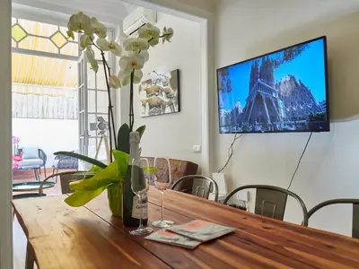 a dining room table with a vase of flowers on it at BarcelonaForRent The Living Terrace in Barcelona