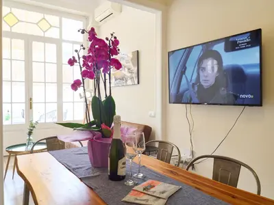 a dining room table with a bottle of wine and flowers at BarcelonaForRent The Living Terrace in Barcelona