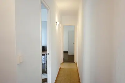 a hallway with a white wall and a mirror at Homenfun Barcelona Park Güell in Barcelona